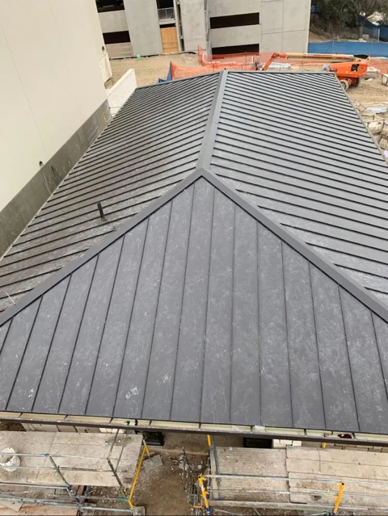 Commercial metal roof construction with crane equipment in Pine Hill